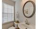 Small bathroom with white sink, toilet, and decorative mirror at 3676 Chattahoochee Summit Dr, Atlanta, GA 30339