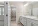 Bathroom with double vanity, white cabinets, and tiled shower with glass door at 6005 Skellig St, Norcross, GA 30071