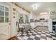 Charming kitchen boasts a checkerboard floor and white cabinets at 1736 Pleasant Grove Rd, Temple, GA 30179