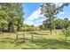 Large grassy backyard with a fenced area and trees at 1736 Pleasant Grove Rd, Temple, GA 30179