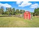 Large backyard with a red shed and garden area at 1736 Pleasant Grove Rd, Temple, GA 30179