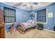 Cozy bedroom with a twin bed, two windows, and blue walls at 1736 Pleasant Grove Rd, Temple, GA 30179