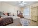 Bedroom with ceiling fan, dresser, and light gray rug at 1736 Pleasant Grove Rd, Temple, GA 30179