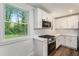 Updated kitchen with white cabinets, stainless steel appliances, and a large window at 408 Belgarde Place Se, Atlanta, GA 30354