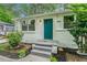 White brick ranch home with teal door, landscaping, and a paved walkway at 408 Belgarde Place Se, Atlanta, GA 30354