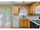 Eat-in kitchen with wood cabinets, built-in microwave, and access to backyard at 3127 Fields Dr, Lithonia, GA 30038