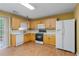Kitchen with light wood cabinets, white appliances, and tile backsplash at 3127 Fields Dr, Lithonia, GA 30038