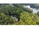 House nestled in a wooded area near a lake and road at 7350 Ono Rd, Palmetto, GA 30268