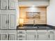 Basement wet bar with white cabinets and a wood backsplash at 7350 Ono Rd, Palmetto, GA 30268