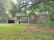 House exterior with a covered porch, attached garage, and surrounded by lush greenery at 115 Elberta St, Mcdonough, GA 30253
