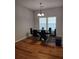 Modern dining room featuring a glass top table, black chairs, and hardwood floors at 115 Elberta St, Mcdonough, GA 30253