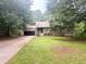 Charming house exterior with a large front yard, driveway, and mature trees providing shade at 115 Elberta St, Mcdonough, GA 30253