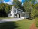 Charming white farmhouse exterior with a spacious lawn and driveway at 3563 Denby Dr, Snellville, GA 30039