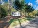 White farmhouse nestled among lush trees with a neatly manicured lawn at 3563 Denby Dr, Snellville, GA 30039