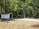 White shed nestled in a wooded backyard setting at 3563 Denby Dr, Snellville, GA 30039