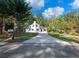 White farmhouse with concrete driveway and a spacious lawn at 3563 Denby Dr, Snellville, GA 30039