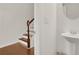Small half bath with pedestal sink and mirror near staircase at 5820 Keystone Pt, Lithonia, GA 30058