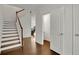 Hardwood floor foyer with staircase and access to half bath and coat closet at 5820 Keystone Pt, Lithonia, GA 30058