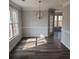 Bright dining room with wood-look flooring, large windows, and a modern chandelier at 20 Wisteria Blvd, Covington, GA 30016