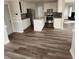 Modern kitchen featuring stainless steel appliances, granite countertops, and wood-look vinyl flooring at 20 Wisteria Blvd, Covington, GA 30016