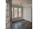 Spacious home office featuring neutral gray walls, large windows, and double white doors at 20 Wisteria Blvd, Covington, GA 30016