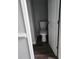 Small, updated bathroom with a pedestal sink, toilet, and dark wood-look flooring at 20 Wisteria Blvd, Covington, GA 30016