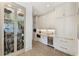 Butler's pantry with glass-front cabinets, wine cooler, and coffee machine at 100 Grand Cres, Alpharetta, GA 30009
