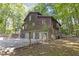 Rear view of a two-story home with a three-car garage and wooded surroundings at 795 Gardner St, Austell, GA 30168