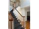 Elegant staircase with wood railing and patterned carpet at 1958 Stonewood Dr, Lithia Springs, GA 30122