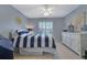 Bright bedroom with a striped comforter, dresser, and window with shutters at 1620 Silverleaf Way, Alpharetta, GA 30005