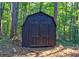 Dark-colored storage shed nestled in a wooded area at 335 Little Creek Dr, Sharpsburg, GA 30277