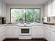 Bright kitchen with white cabinets, stainless steel appliances, and wooded views at 285 Glen Lake Dr, Atlanta, GA 30327