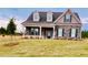 Beautiful two-story home with stone and siding exterior, front porch, and landscaped yard at 3940 Foxdale Ln, Cumming, GA 30028
