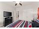 Bedroom with TV, ceiling fan, and red and gray bedding at 2536 Skyland Ne Dr, Atlanta, GA 30319