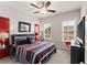 Main bedroom with TV, ceiling fan, and red and gray bedding at 2536 Skyland Ne Dr, Atlanta, GA 30319