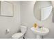 Small bathroom with pedestal sink and round mirror at 2527 Swan Lake Dr, Grayson, GA 30017