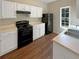 Modern kitchen with white cabinets, black appliances, and laminate flooring at 20 Pine Canyon Sw Dr # 24, Atlanta, GA 30331