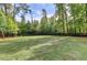 Spacious backyard with a large grassy area and trees at 1720 Mountainside Dr, Cumming, GA 30040