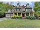 Two-story house with stone accents, a red door, and a landscaped lawn at 1720 Mountainside Dr, Cumming, GA 30040