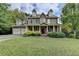 Two-story house with stone accents, a red door, and a landscaped lawn at 1720 Mountainside Dr, Cumming, GA 30040