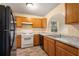 View of kitchen with wood cabinets, white appliances, and granite countertops at 3869 Merryweather Trl, Austell, GA 30106