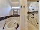 Elegant bathroom featuring a soaking tub, walk-in shower, and marble tile at 6308 Woodlake Dr, Buford, GA 30518