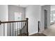 Upstairs hallway with a wooden railing and window overlooking backyard at 3445 Andover St, Cumming, GA 30028