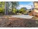 Spacious backyard with a large patio, surrounded by trees and landscaping at 1712 Country Wood Dr, Hoschton, GA 30548