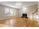 Living room with hardwood floors, fireplace, and stairs to upper level at 1712 Country Wood Dr, Hoschton, GA 30548