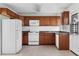 Kitchen with wood cabinets, white appliances, and tile flooring at 3589 Orchard Cir, Decatur, GA 30032