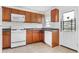 Kitchen with wood cabinets, white appliances, and tile flooring at 3589 Orchard Cir, Decatur, GA 30032