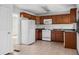 Kitchen with wood cabinets, white appliances, and tile flooring at 3589 Orchard Cir, Decatur, GA 30032