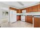 Kitchen with wood cabinets, white appliances, and tile flooring at 3589 Orchard Cir, Decatur, GA 30032