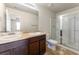 Bathroom with dark brown vanity, double sinks, and a glass shower at 6327 Olmadison Pl, South Fulton, GA 30349